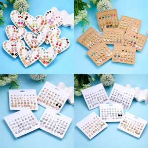 Dettaglio di un set di orecchini a lobo con motivi floreali, a cuore e forme geometriche
