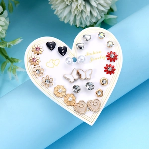 Dettaglio di 12 paia di orecchini geometrici e fiori su un cartoncino a cuore