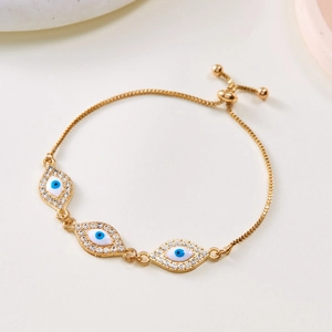 Detail von drei blauen Nazar-Augen mit Strass auf verstellbarem goldenem Armband