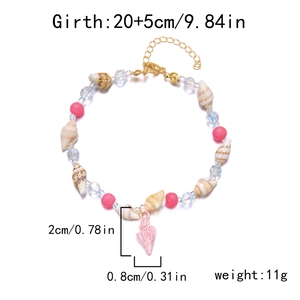 Close-up of handmade shell anklet with pink beads, gold lobster clasp and size labels