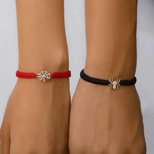 Détail des bracelets en corde tressée rouge et noire avec breloques araignée et toile
