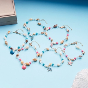 Flat lay of sea shell beach anklets set with turquoise beads and starfish charms