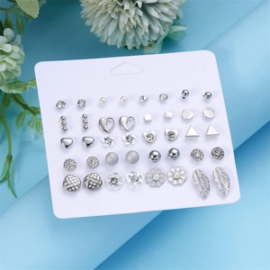 Dettaglio del set di 12 paia di orecchini geometrici color argento con perle e cristalli