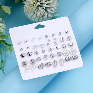 Dettaglio del set di 12 paia di orecchini geometrici con perle e cristalli su espositore