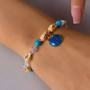Detail of beach shell bracelet with turquoise beads and blue scallop shell charm