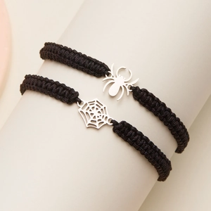 Détail de bracelets d'Halloween tissés noirs avec breloques araignée et toile argentées