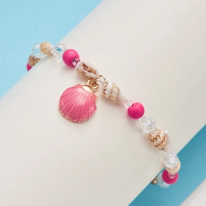 Detailed shot of ocean-style bracelet with shell charm, pink beads and faceted crystals
