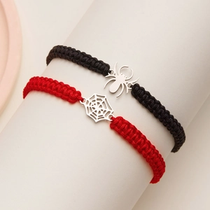 Détail de bracelets d'Halloween tissés avec breloques araignée et toile argentées