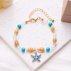 Detail of beaded shell bracelet featuring blue starfish charm and golden lobster clasp