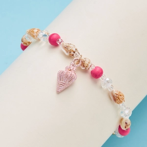 Detailed shot of pink beads and natural shells bracelet with rose gold shell charm