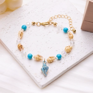 Detailed shot of summer shell bracelet with blue beads and golden lobster clasp