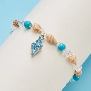 Detail of beach shell bracelet with turquoise beads and blue pendant on display