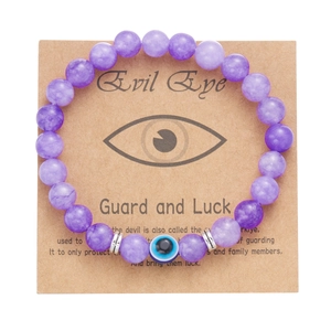 Bracciale di perle viola con occhio greco su un supporto in carta kraft decorativo