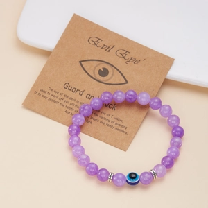 Bracciale di perline viola con ciondolo occhio del diavolo blu su carta kraft