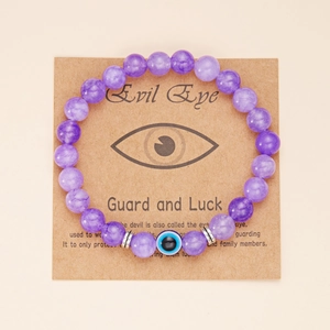 Dettaglio del bracciale con perline viola malocchio su cartoncino kraft vintage