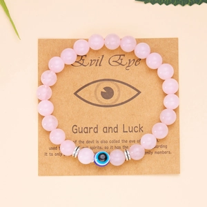 Bracciale di perline rosa con occhio del male su cartoncino informativo in carta kraft