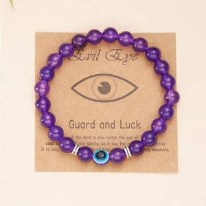 Dettaglio del bracciale con perline viola Evil Eye su cartoncino regalo in carta kraft