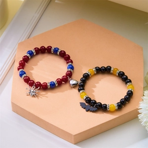 Détail de bracelets magnétiques pour couple avec breloques Batman et Spider-Man