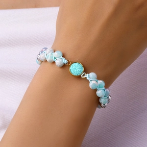 Primer plano de la pulsera de piedra azul claro tejida a mano con cristal druzy en la muñeca