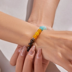 Tiger eye and natural stone bead bracelet with metal spacers shown on female wrist
