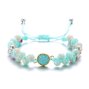 Primer plano de pulsera artesanal con cuentas de piedra natural azul y cordón ajustable