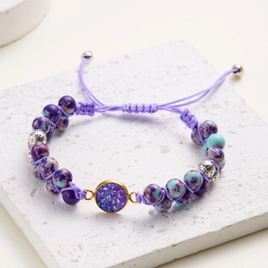 Pulsera artesanal de piedra natural tejida con cuentas púrpuras y cordón ajustable