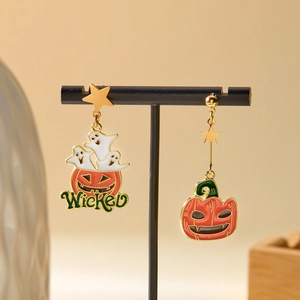 Detailed shot of Halloween pumpkin ghost earrings with Wicked lettering on jewelry stand