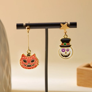 Asymmetric Halloween drop earrings featuring red pumpkin and white skull on a stand