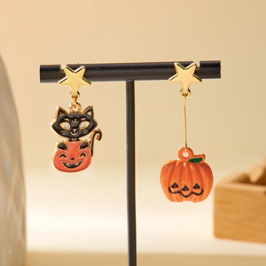 Detail of asymmetric Halloween earrings with black cat on pumpkin and golden star studs