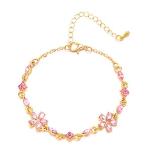 Nahaufnahme eines goldenen Blumenarmbands mit rosa Kristallblüten und verstellbarer Schließe