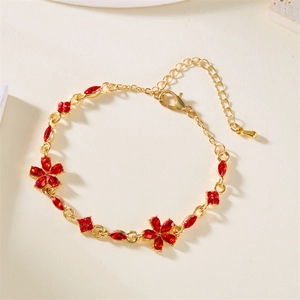 Detailansicht des goldenen Blumenarmbands mit roten Kristallen und verstellbarer Kette