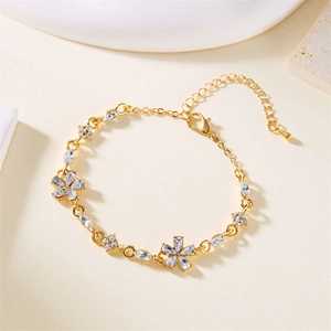 Nahaufnahme eines goldenen Blumenarmbands mit Zirkonia-Blüten und verstellbarer Kette