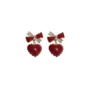 Red bow stud earrings with pearls, rhinestones, and dark red heart-shaped pendants
