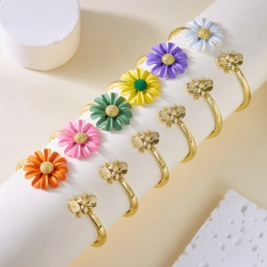 Detail van madeliefjes en bijen ringen set met kleurrijk emaille en gouden afwerking