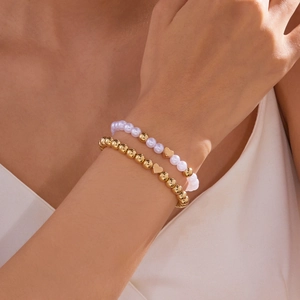 Elegante set van goudkleurige metalen kralen en witte parelarmbanden met hartjesbedels