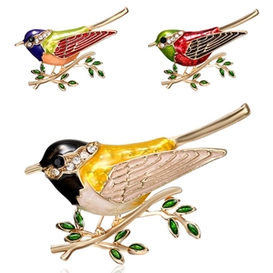 Elegante broche de pájaro en rama con esmalte colorido y cristales brillantes en oro
