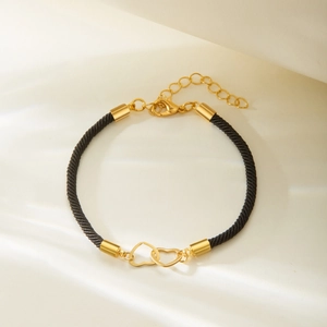 Adjustable black woven rope bracelet with interlocking gold hearts and lobster clasp