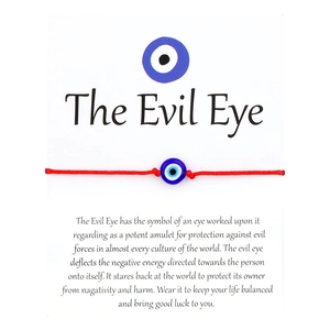 Λεπτομέρεια κόκκινου βραχιολιού Evil Eye σε λευκή κάρτα με συμβολικό κείμενο