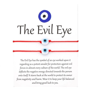 Σετ δύο κόκκινα πλεκτά βραχιόλια Evil Eye σε διακοσμητική κάρτα παρουσίασης