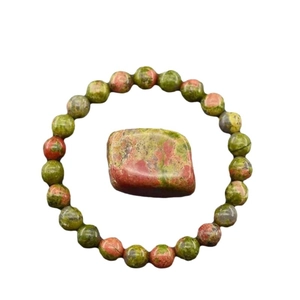 Elastisches Armband mit 8mm Unakite-Perlen und poliertem Stein auf weißem Grund