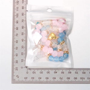 Dettaglio di bracciali con perline, chiusura magnetica a cuore e righello per misura