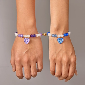 Dettagli dei ciondoli a cuore magnetico su braccialetti di perle per coppie blu e viola