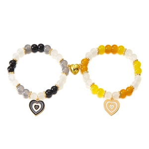 Dettaglio delle chiusure magnetiche a cuore e braccialetti di perline per coppie colorati