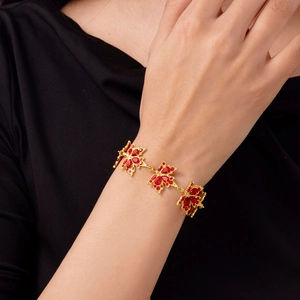 Primo piano dell'originale bracciale a foglia d'acero dorata con cristalli rossi