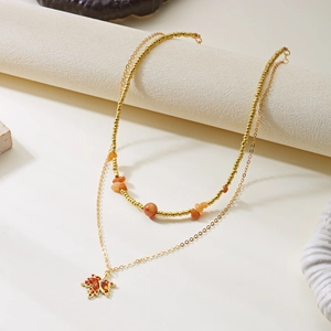 Elegante collana a due strati in oro con ciondolo a foglia d'acero e pietre arancioni