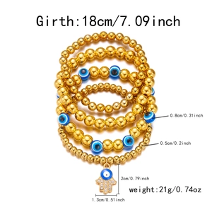 Detail van 5 gouden kralenarmbanden met blauwe boze oog kralen en Hamsa Hand bedeltje
