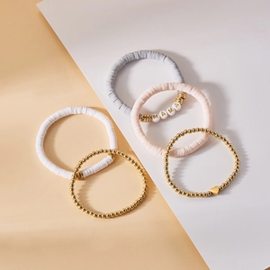 Detailliertes Set aus fünf Perlenarmbändern mit MAMA-Buchstaben und Goldherz-Anhänger