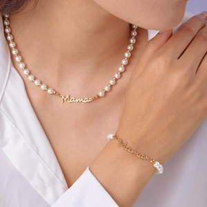 Détail de l'ensemble collier et bracelet en perles avec pendentif Mama doré élégant