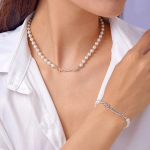 Détail de l'ensemble collier et bracelet Mama en perles porté par un mannequin en blanc