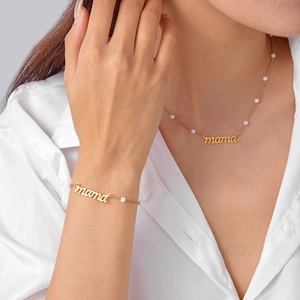 Détail de l'ensemble collier et bracelet MAMA doré avec perles blanches sur modèle